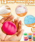 Hands holding pink dough next to ingredients and 12 color dough cans from 3 In 1 Color Dough Kitchen Creations Set With Ice Cream Maker Spaghetti And Burger Tools Art Craft Food Modeling Toys Accessories Kit For Boys Girls Kids Toddlers Ages 3 Plus Includes 12 Color Dough