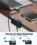 Clamp On USB Hub With External Power Sleek Aluminum 4 Port USB 3.0 Adapter mounted on desk edge beside laptop and devices.