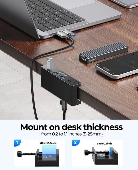 Clamp On USB Hub With External Power Sleek Aluminum 4 Port USB 3.0 Adapter mounted on desk edge beside laptop and devices.