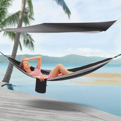 Woman relaxing in Heavy Duty Camping Hammock With Rain Fly Tarp And Mosquito Net 440 Lb Capacity Portable Tree Hammock by beach.