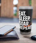 Black tumbler with 'Eat. Sleep. Soar. Repeat' text, on a table next to a phone and keys. Glider Pilot Stainless Steel Insulated Tumbler Keeps Coffee Hot Or Ice Cold For Sailplane Fans, Flight Crew, And Flight School Students On Ridge Soaring, Tow Launches, And Club Flights.