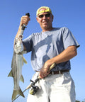 Angler using Pro Grade Fish Lip Gripper Pliers With Upgraded 4.3 Inch EVA Foam Handle for holding catch against blue sky