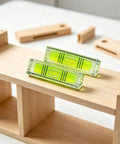 2 Pack Magnetic Mini Bubble Level Tool 2 Inch, Small Pocket on a wooden shelf for easy leveling of objects.