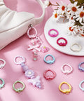 14 Color Spring Gate Ring Set For Keychains And Craft Projects With Strawberry Trigger Snap Buckles displayed on pink surface with flowers and bag