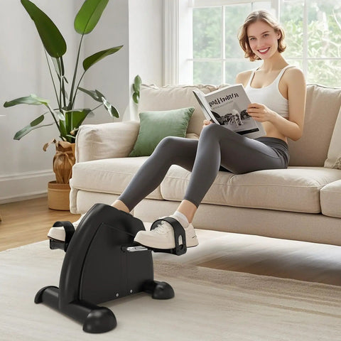 Woman using Under Desk Elliptical And Mini Exercise Bike For Easy At Home Or Office Workouts, Seated Leg And Arm Exerciser in living room