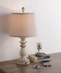Farmhouse Style Table Lamp with USB Charging Port, white washed rustic finish, 22 inch with tapered drum shade, on a wooden table