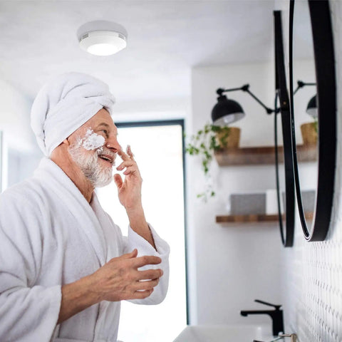 Man grooming in bathroom with Bathroom Integrated LED Light Ceiling Mount Exhaust Ventilation Fan Quiet One Point One Sones 80 CFM
