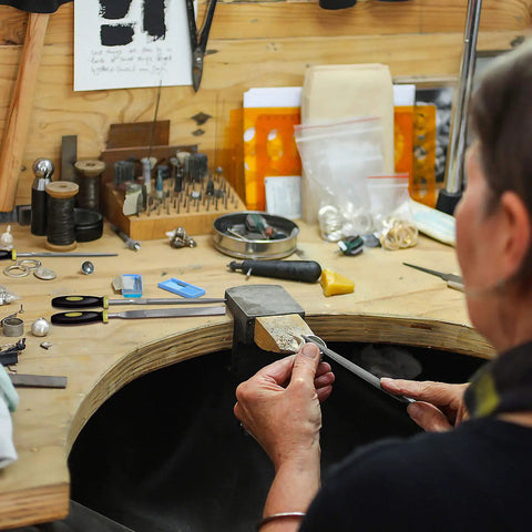 Person using Pro Grade Metal File Set With 12 Needle Files And Storage Bag Including Large Flat Half Round Triangle And Round Files Plus Steel Brush for woodworking at a workbench.