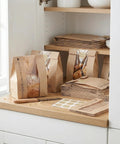 Clear Window Bread Bags For Homemade Bread Keep Sourdough Fresh For Days And Make Gifting Your Bakes A Breeze Eco Friendly Kraft Paper Packaging For Bakery Goods showing kraft bags with clear windows and stickers on a shelf.