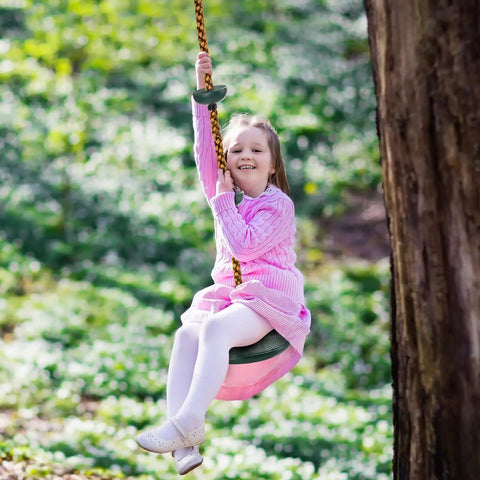 Child swinging on Outdoor Climbing Rope With Platform And Disc Swing Seat Set for Trees and Backyards, attached to tree