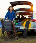 Person with Oversized Folding Camping Chair With 500 Lbs Support, Padded Cushion And Built-In Cooler Pockets