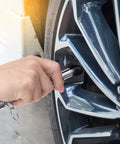Dual-head tire pressure gauge in silver being used on a car tire valve stem