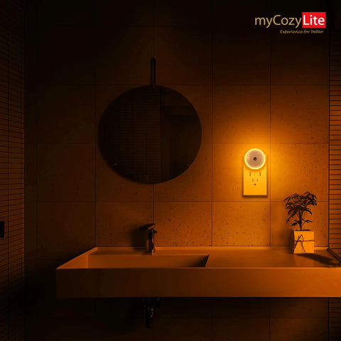 Amber Night Light Plug In Dusk To Dawn Sensor Night Light illuminating a bathroom with warm amber glow next to a sink.
