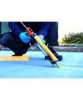 Worker applying Sikaflex 1C SL Self Leveling Polyurethane Sealant for limestone and concrete expansion joints on a sidewalk.