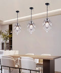 Crystal Mini Black Chandelier With Adjustable 41.3 Inch Chain illuminating modern dining area with white chairs.
