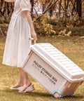 Heavy Duty Rolling Bin With Secure Lid And Easy Roll Casters, Stackable Outdoor Camp Organizer being pulled on grass.