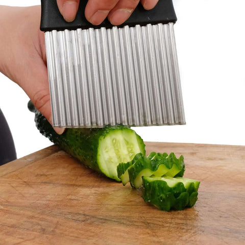 HTBMALL stainless steel crinkle cutter with black handle, close-up view slicing cucumber on a wooden cutting board