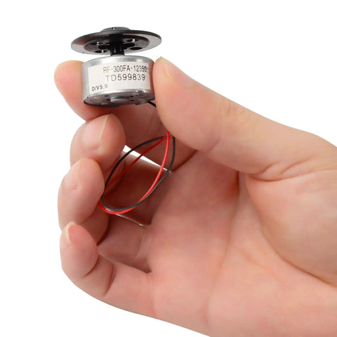 Hand holding DC Five Point Nine Volt Spindle Motor For DVD CD Players With Metal RF300FA12350 Micro Motor Replacement Part
