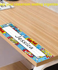 Image of a 36 Pack Classroom Name Plates For Kids With Large Writing Space on a wooden desk, showing colorful design and name 'Jessica'. 