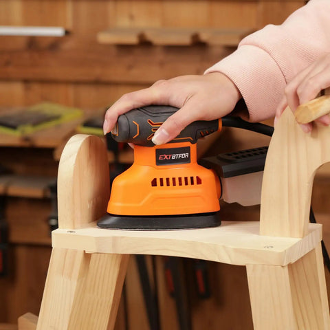 Electric Orbital Detail Sander Pumping Out 14000 OPM With Seamless Dust Collection on a wooden stool.