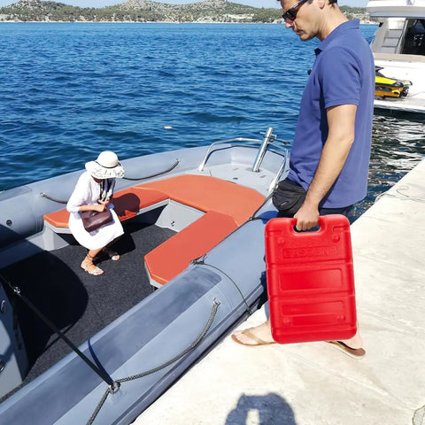 Man holding Six Gallon Marine Fuel Transfer Tank With 9.8 Ft Hose Built In Gauge I Shaped Handle And Leakproof Cap on a boat dock