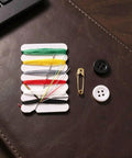 The Go-To 200 Piece Mini Travel Sewing Repair Kit That Slashes Tailor Bills While You Fix Snags On The Fly Without Breaking A Sweat Compact Pocket Gear For Campers Students And Travelers with threads, buttons, and safety pin on a textured surface.