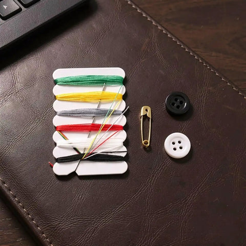 The Go-To 200 Piece Mini Travel Sewing Repair Kit That Slashes Tailor Bills While You Fix Snags On The Fly Without Breaking A Sweat Compact Pocket Gear For Campers Students And Travelers with threads, buttons, and safety pin on a textured surface.