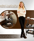 3 Tier Metal Rolling Utility Cart With Walnut Top placed next to a bed, showing practicality and spatial aesthetics with cosmetics and coffee settings
