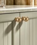 Premium Zinc Alloy Cabinet Knobs And Drawer Pulls One Inch Round Ball Champagne Bronze Finish on a kitchen cabinet door.