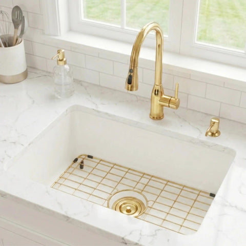 Gold Stainless Steel Sink Grid in a white kitchen sink with a centered drain hole, surrounded by a marble countertop and gold faucet.