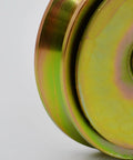 Close-up of Badass Heavy Duty Galvanized 4 Inch V Groove Wheel with precision bearing, showcasing its gold finish and smooth surface.