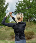 Person using Stainless Steel Golf Swing Trainer For Power And Flexibility Training in a backyard setting with trees