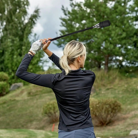 Person using Stainless Steel Golf Swing Trainer For Power And Flexibility Training in a backyard setting with trees