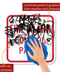 Hand wiping graffiti off K-5834-AL-12x12 Fire Alarm Control Panel Sign Red On White Aluminum Outdoor Ready Laminated Weatherproof Graffiti Resistant