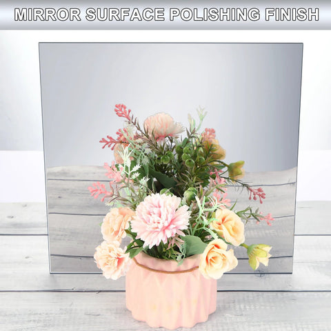 Pink ribbed ceramic vase with pastel artificial flowers in front of a large mirrored surface.