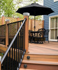 Wooden deck with 4x4 Solar Post Cap Lights, table with umbrella, and railing, showcasing deck lights for outdoor ambiance.