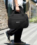 Person carrying 16 inch black lightweight underseat carry on bag for air travel tote weekender duffle personal item under seat fit