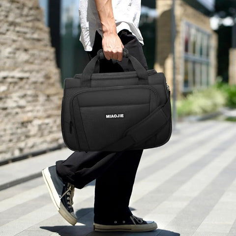 Person carrying 16 inch black lightweight underseat carry on bag for air travel tote weekender duffle personal item under seat fit