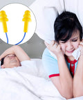 Woman trying to sleep next to snoring partner; inset shows yellow corded ear plugs for noise canceling.