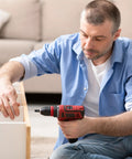 Man using a hammer drill with Rock Solid Five Piece T15 Torx Screwdriver Bits With Center Hole For Hammer Drill And Impact Drivers 1/4 Inch Hex Shank One Inch Long Premium Heat Treated S2 Steel Tough As Nails Power Tool Bits Black.