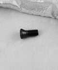 10 Piece Pack Of Heavy Duty Black Carbon Steel M4X10MM Torx Screws Featuring T15 Drive And 12.9 Grade Build on wood surface.