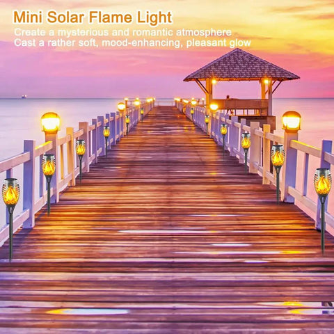 Wooden pier illuminated with Mini Solar Flame Light creating a warm, ambient glow at sunset.