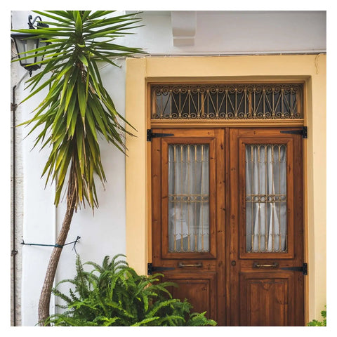 Wooden door with decorative ironwork hinges, similar to Six Inch T Shape Beefy Rustproof Iron Light Duty Shed Hinge Set for DIY gates