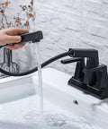 Person using Two Handle Centerset Slick Black Bathroom Sink Faucet With Pull Out Sprayer 3 Hole 4 Inch Lavatory Mixer Tap