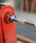 MT2 Cleaner For Wood Lathe Spindles inserted in lathe headstock showing wooden build and one-hand tap design.
