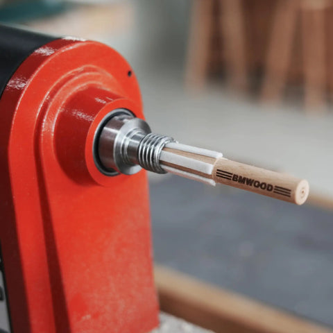 MT2 Cleaner For Wood Lathe Spindles inserted in lathe headstock showing wooden build and one-hand tap design.