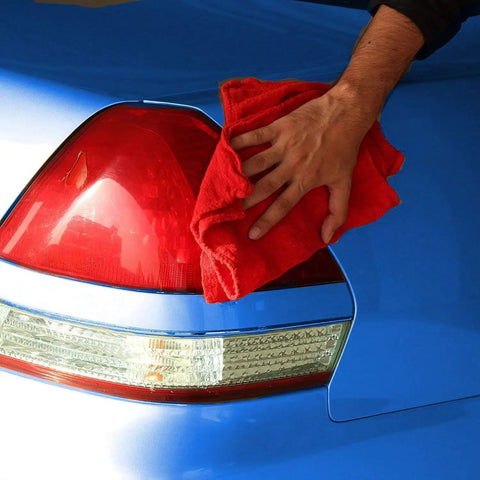 Person using Industrial Grade Cotton Shop Towels 12x14 Inches, 500 Pack Red Reusable Cleaning Rags on car tail light