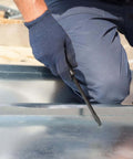 Person using 12 Inch Duct Slitter Hand Sheet Slicer For Cutting Metal Pipes And Duct Work Demolition Tool on metal sheet