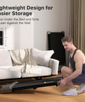 Portable Under Desk Walking Pad Treadmill With Remote And 300 Lb Capacity Hassle Free Setup Compact Home Office Fitness Gear To Clock Up Steps While You Type In Gray being stored under a sofa.