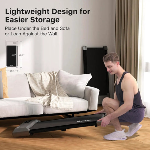 Portable Under Desk Walking Pad Treadmill With Remote And 300 Lb Capacity Hassle Free Setup Compact Home Office Fitness Gear To Clock Up Steps While You Type In Gray being stored under a sofa.